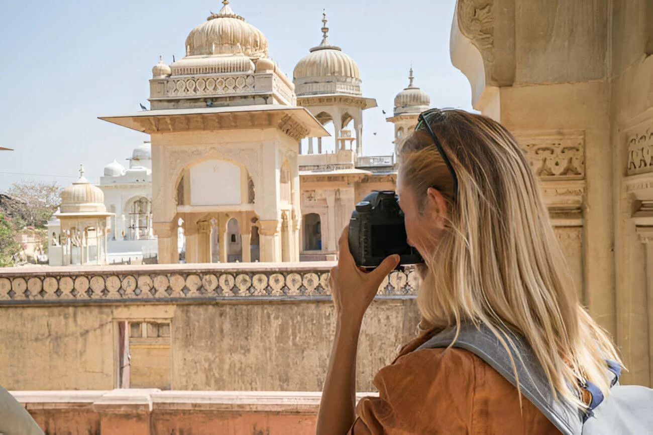 a tourist photographing ancient temple using camera in jaipur rajasthan