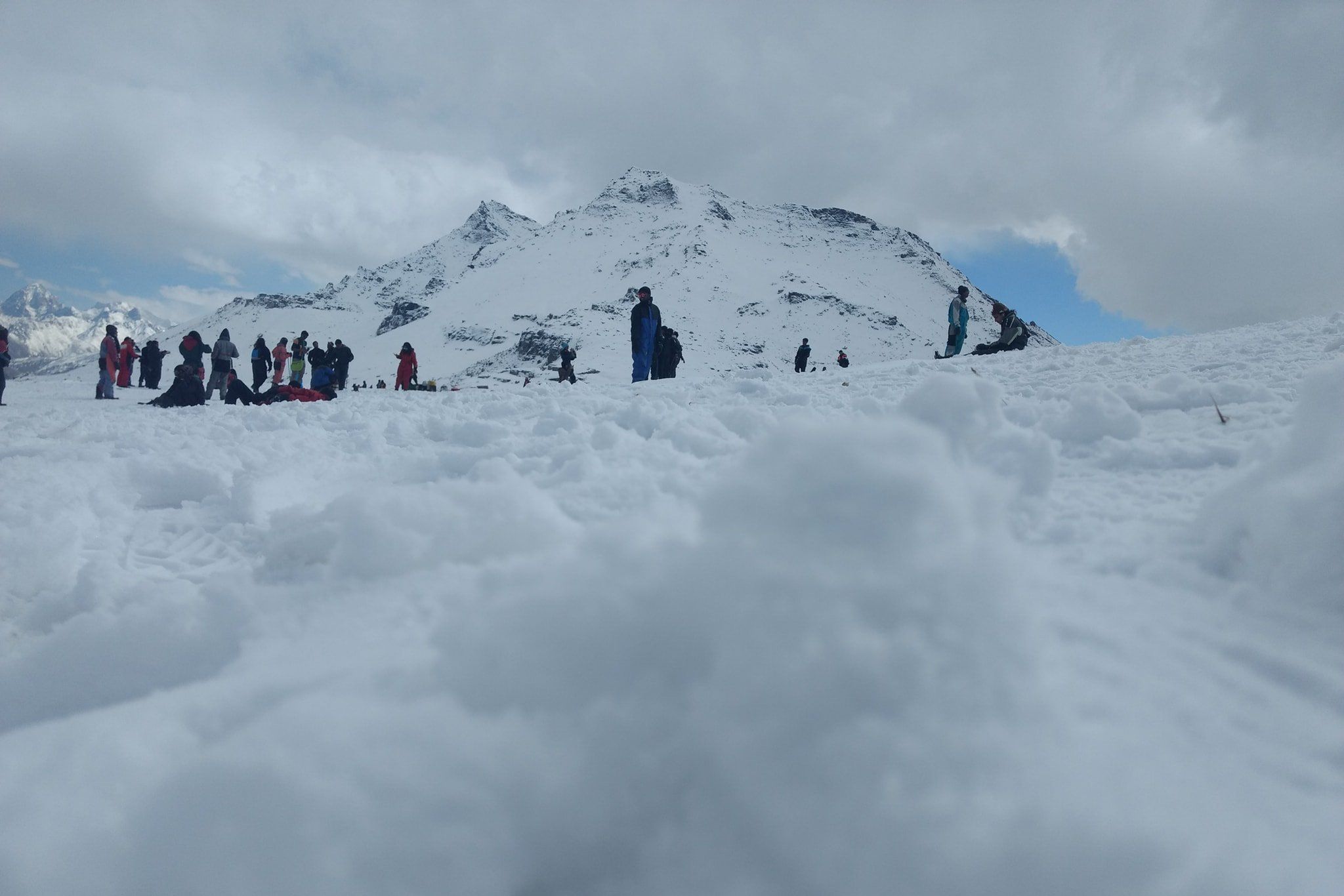 tourist enjoying snow at rohtang pass during daytime