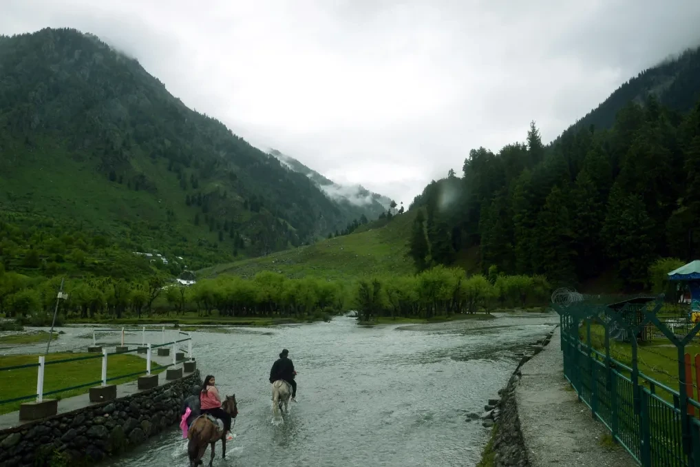tourists riding horse in betaab valley at pahalgam
