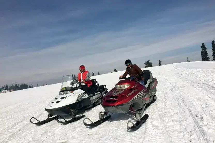 tourists riding snow scooter