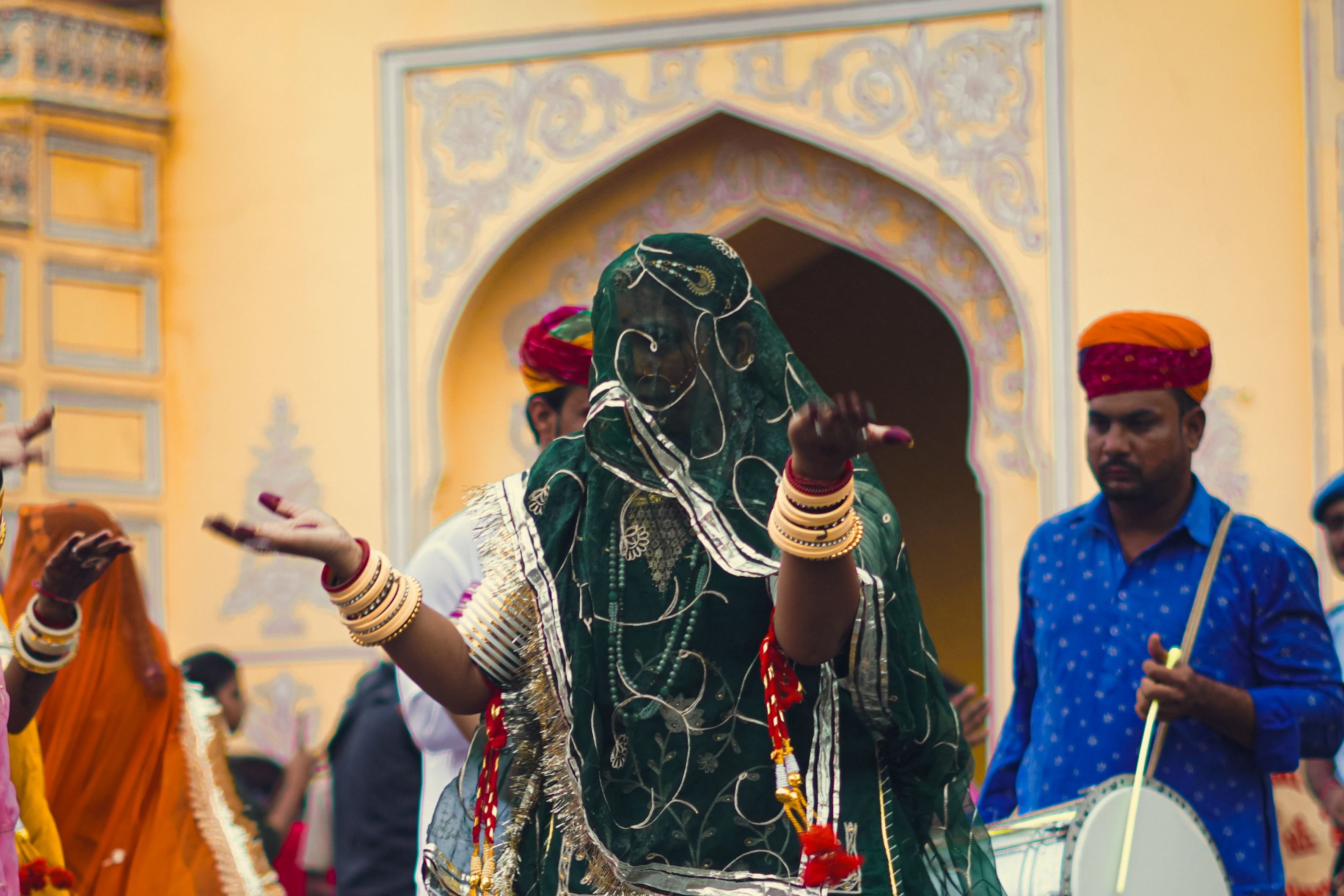an indian woman dancer in colorful attire performing with live music
