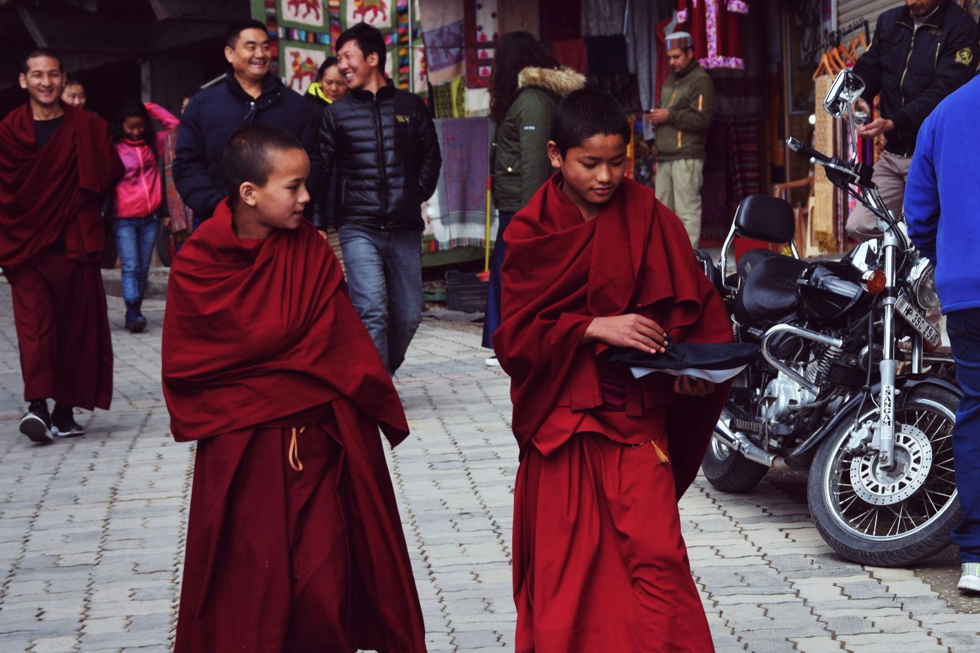 two monks walking down in an alley in mcleodganj