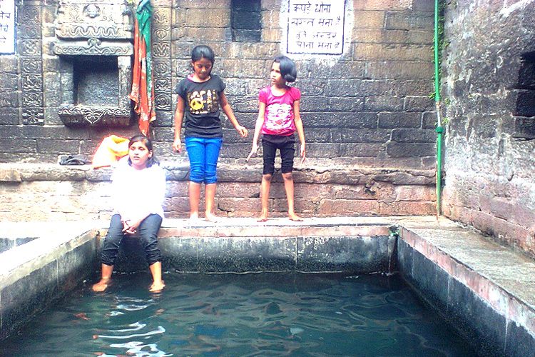 people sitting near vashisht hot water spring