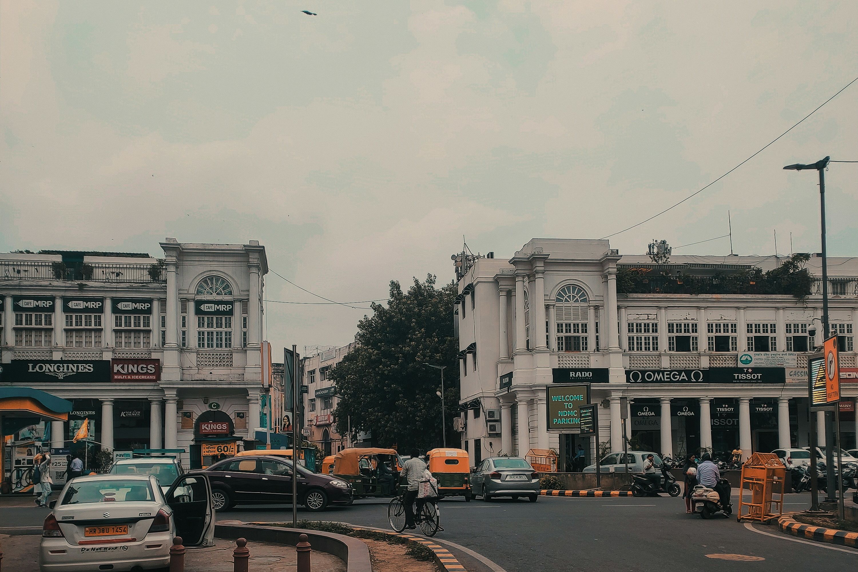vehicles traveling on road during daytime at connaught place in new delhi