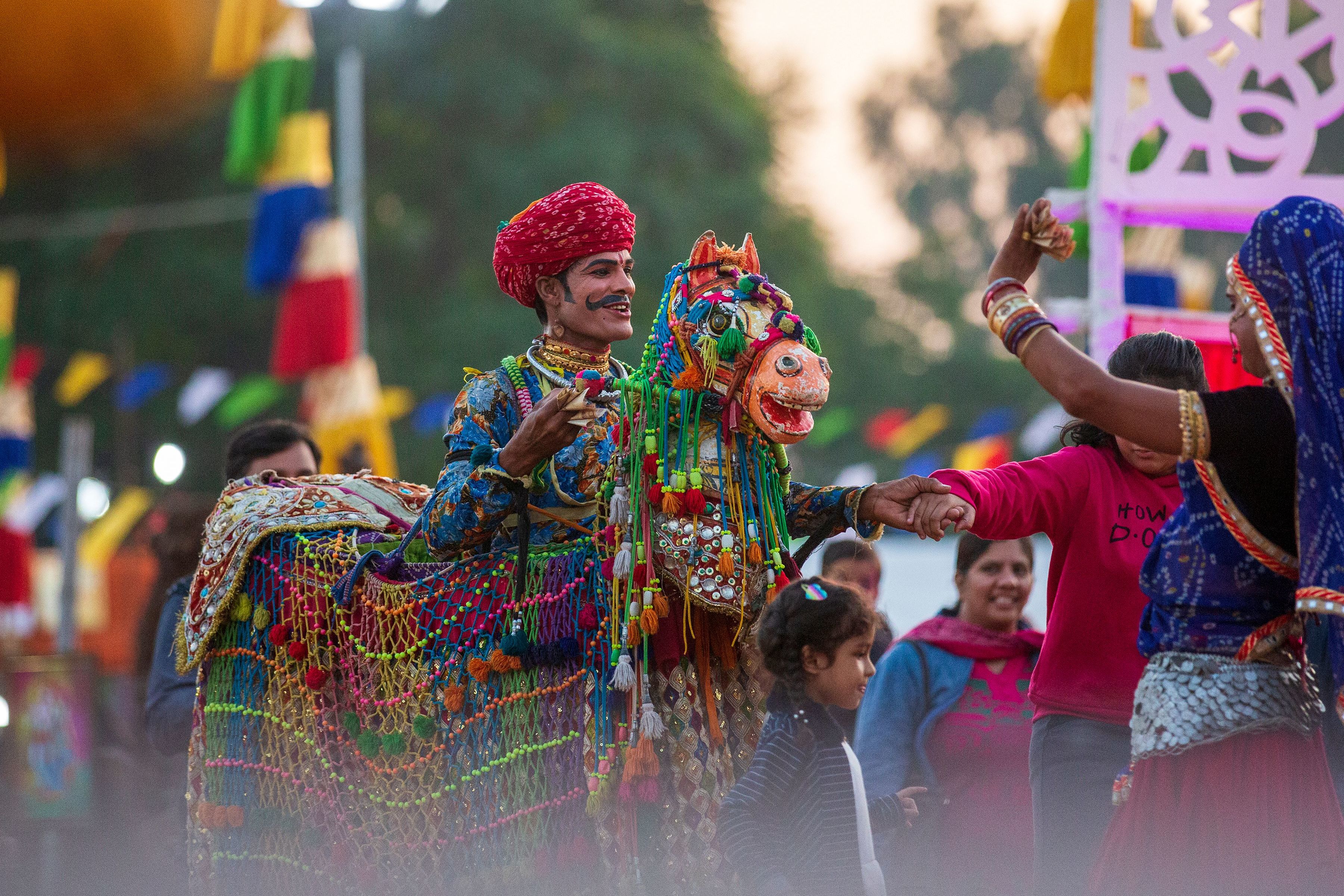 vibrant celebration with a traditionally dressed man and ornate horse costume at an indian festival in rajasthan