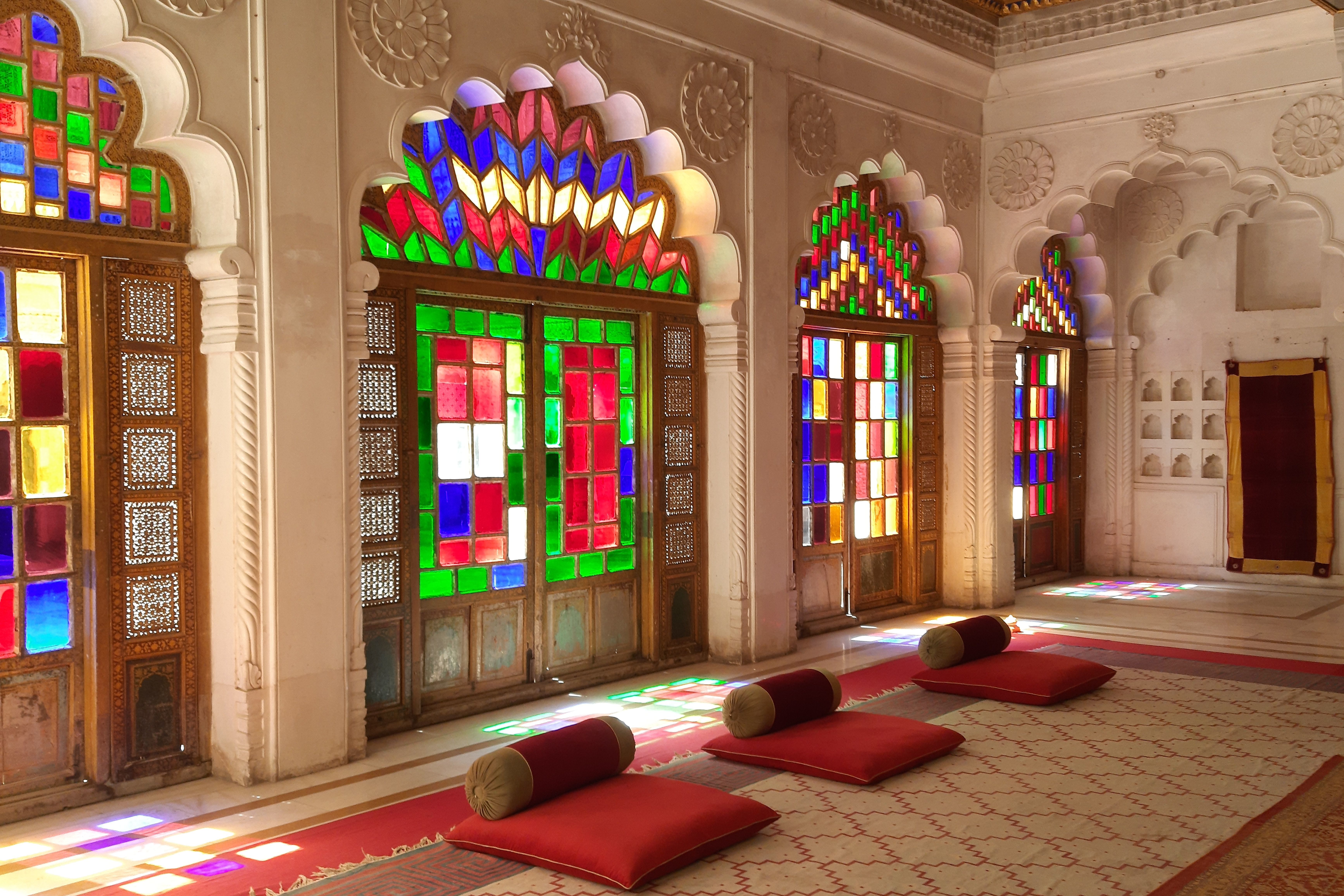 vibrant stained glass widows illuminating a richly decorated historic moti mahal in jodhpur