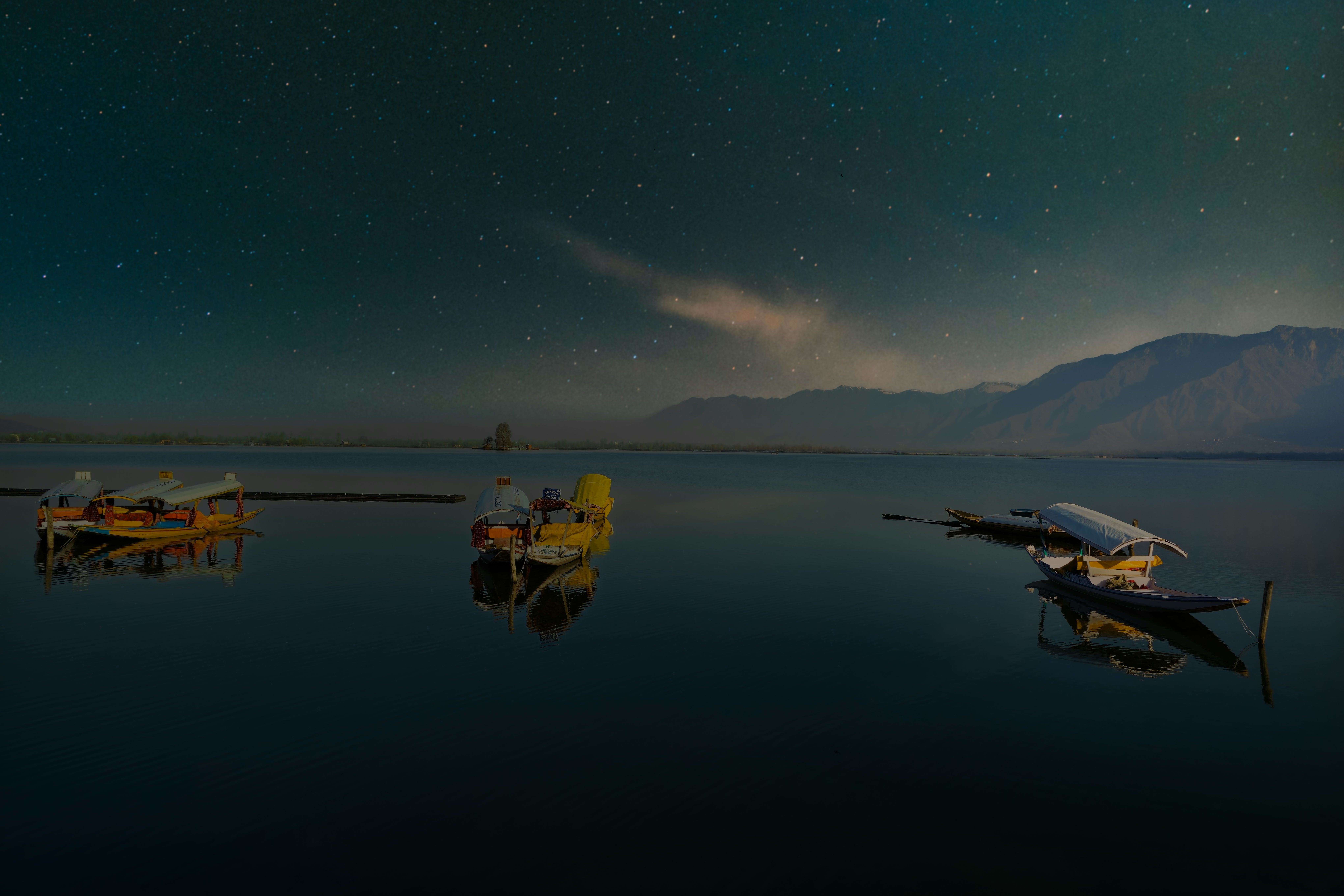 view of boats on the dal lake at night in srinagar