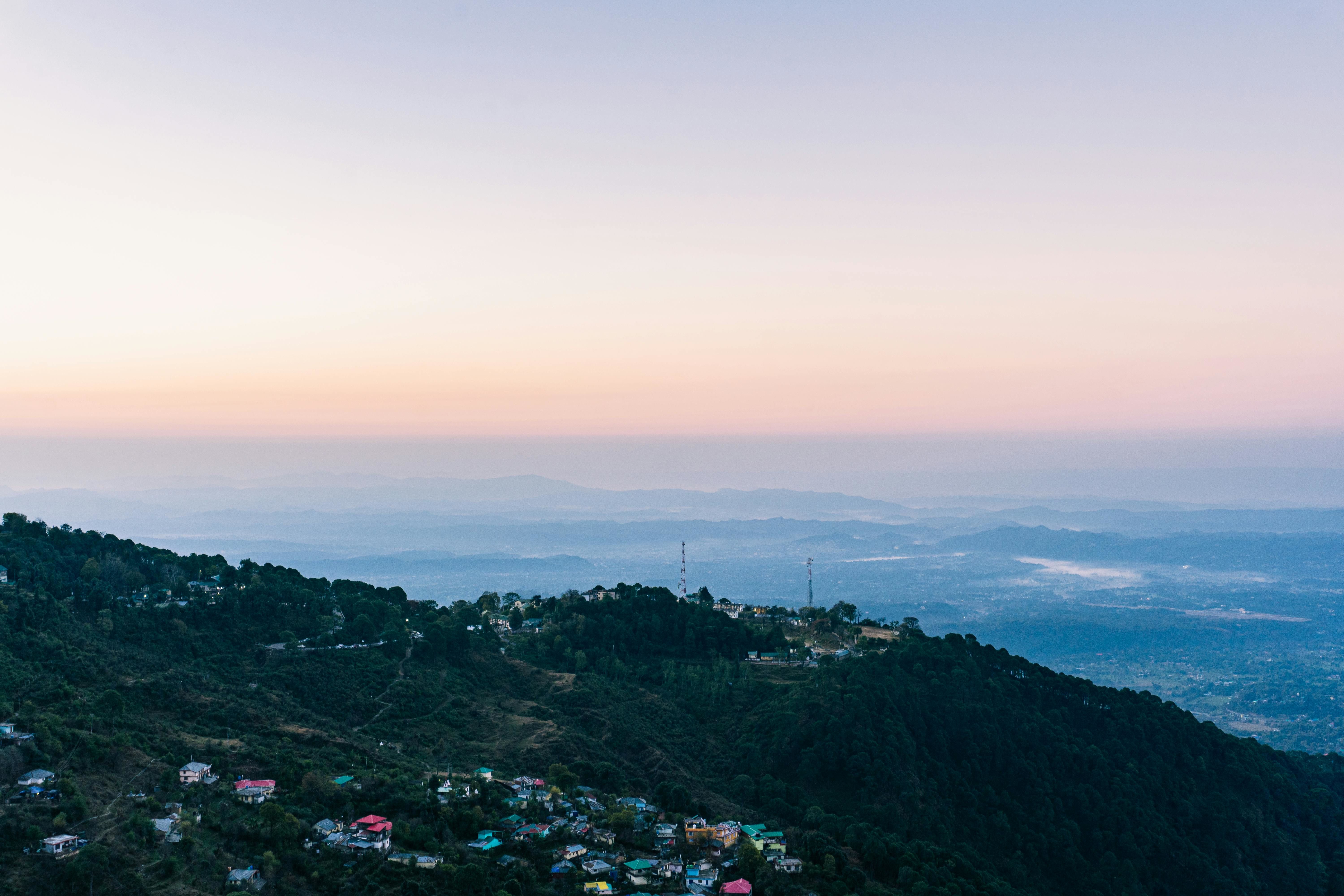 a village on a hill at sunset at dalhousie