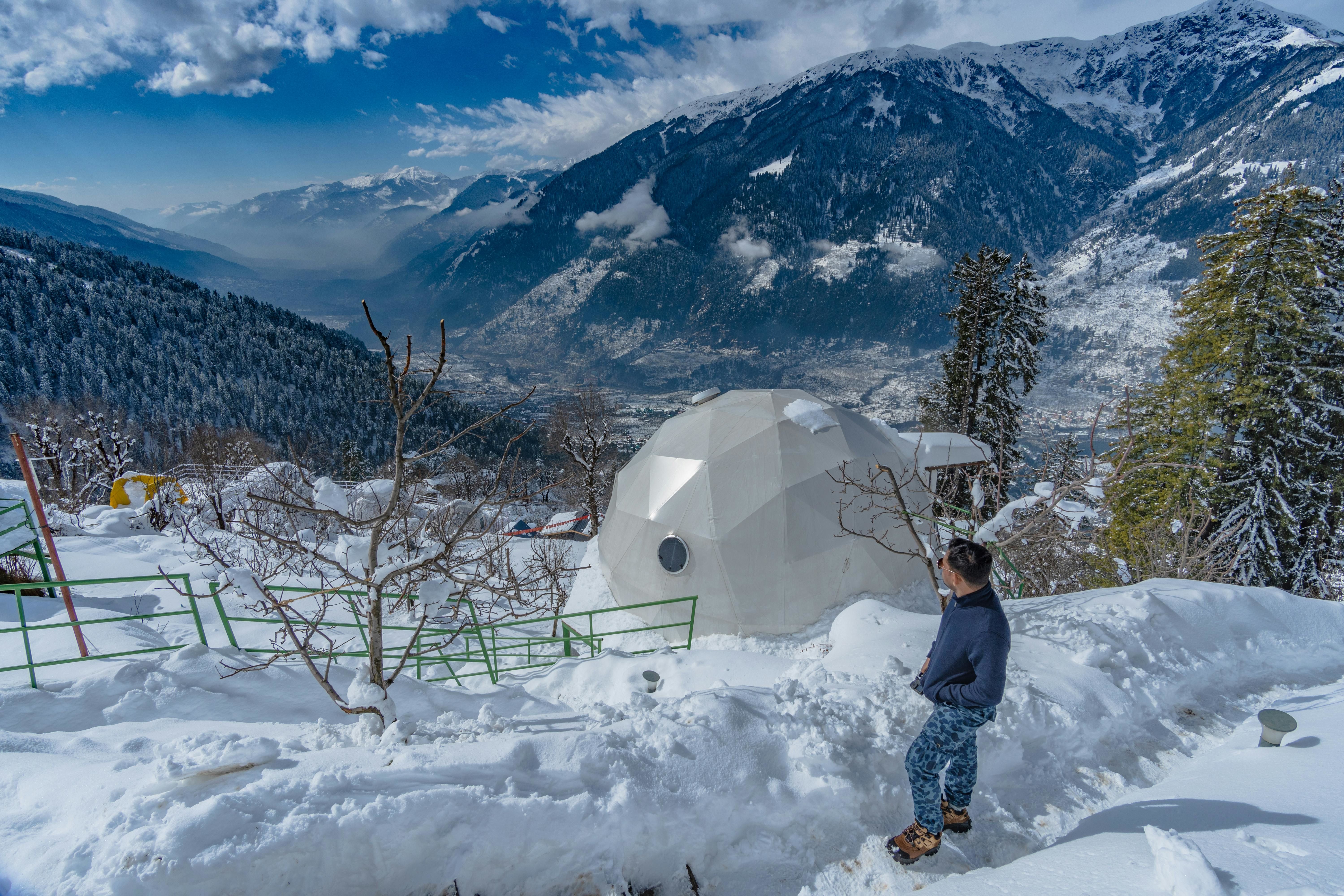 a person standing near a snow covered mountain top in sethan in himachal pradesh