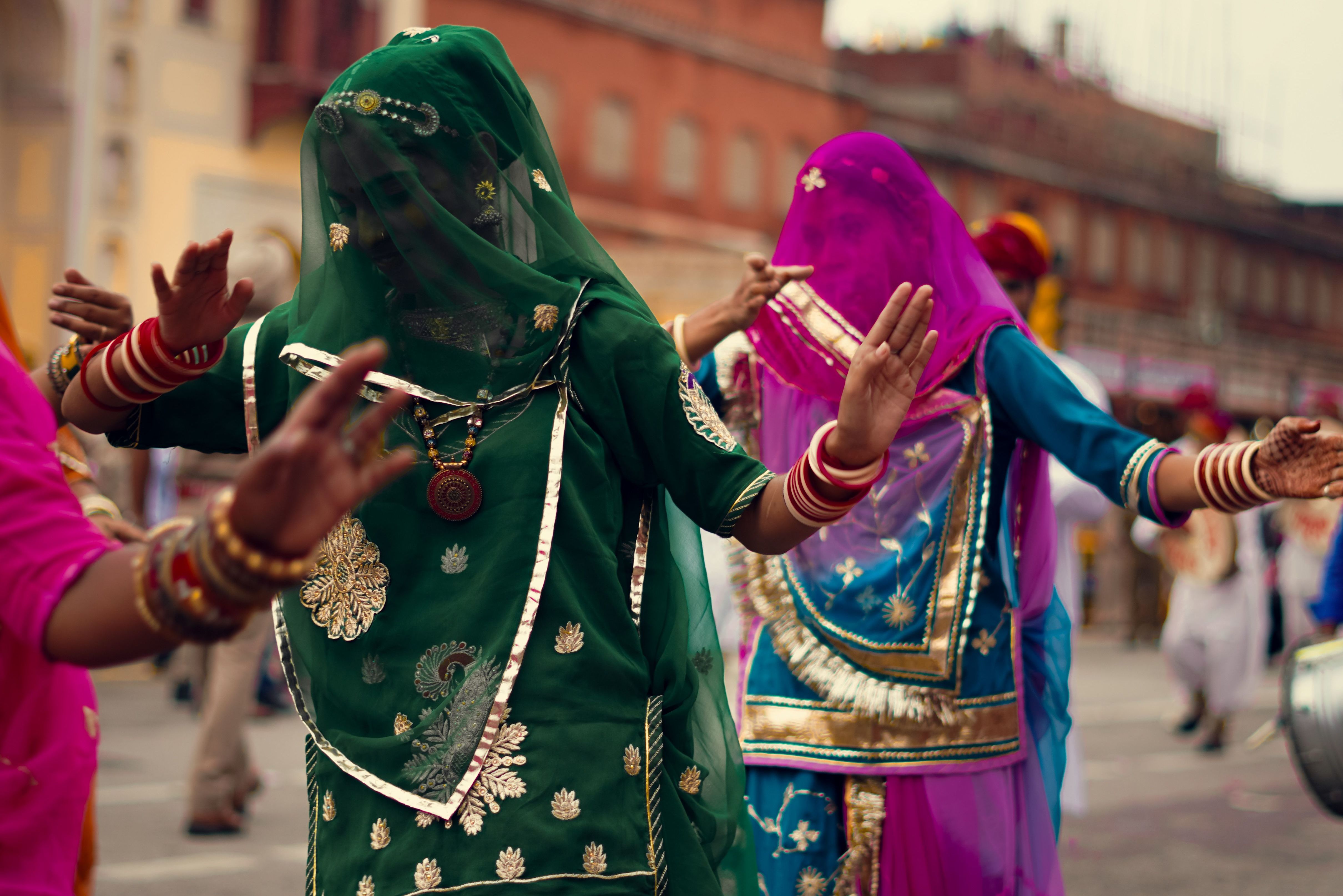 women in vibrant traditioanl clothing performing a cultural dance at a festival in rajasthan