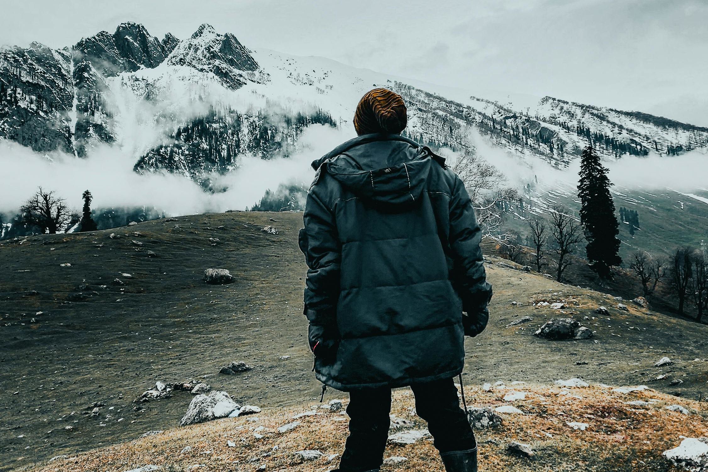 a young woman looking at the view of mountains in the winter